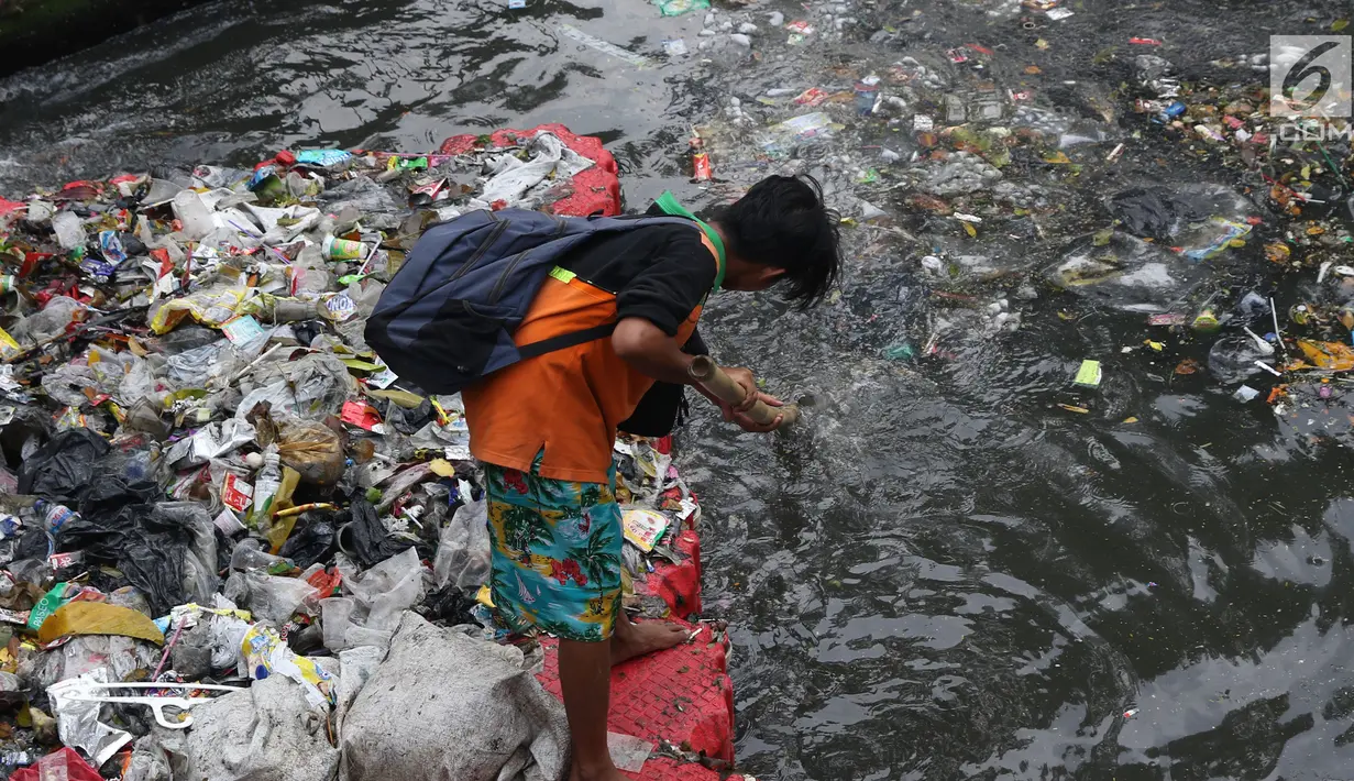 Salah satu petugas UPK Badan Air Dinas Lingkungan Hidup DKI Jakarta mengangkut ceceran sampah di Kali Cideng, Jakarta, Jumat (9/11). Pembersihan untuk mencegah terjadinya penumpukan sampah saat musim hujan di Jakarta. (Liputan6.com/Helmi Fithriansyah)