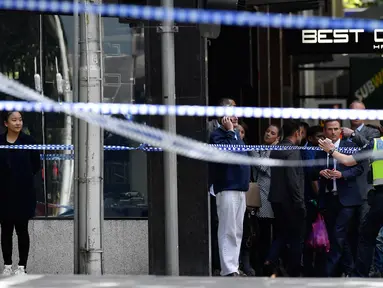 Petugas kepolisian melarang sejumlah orang mendekati lokasi dimana sebuah mobil menghantam para pejalan kaki di pusat kota Melbourne, Australia, Jumat (20/1). Tiga orang tewas dan 20 orang lainnya luka-luka dalam insiden itu. (AP Photo/Andrew Brownbill)