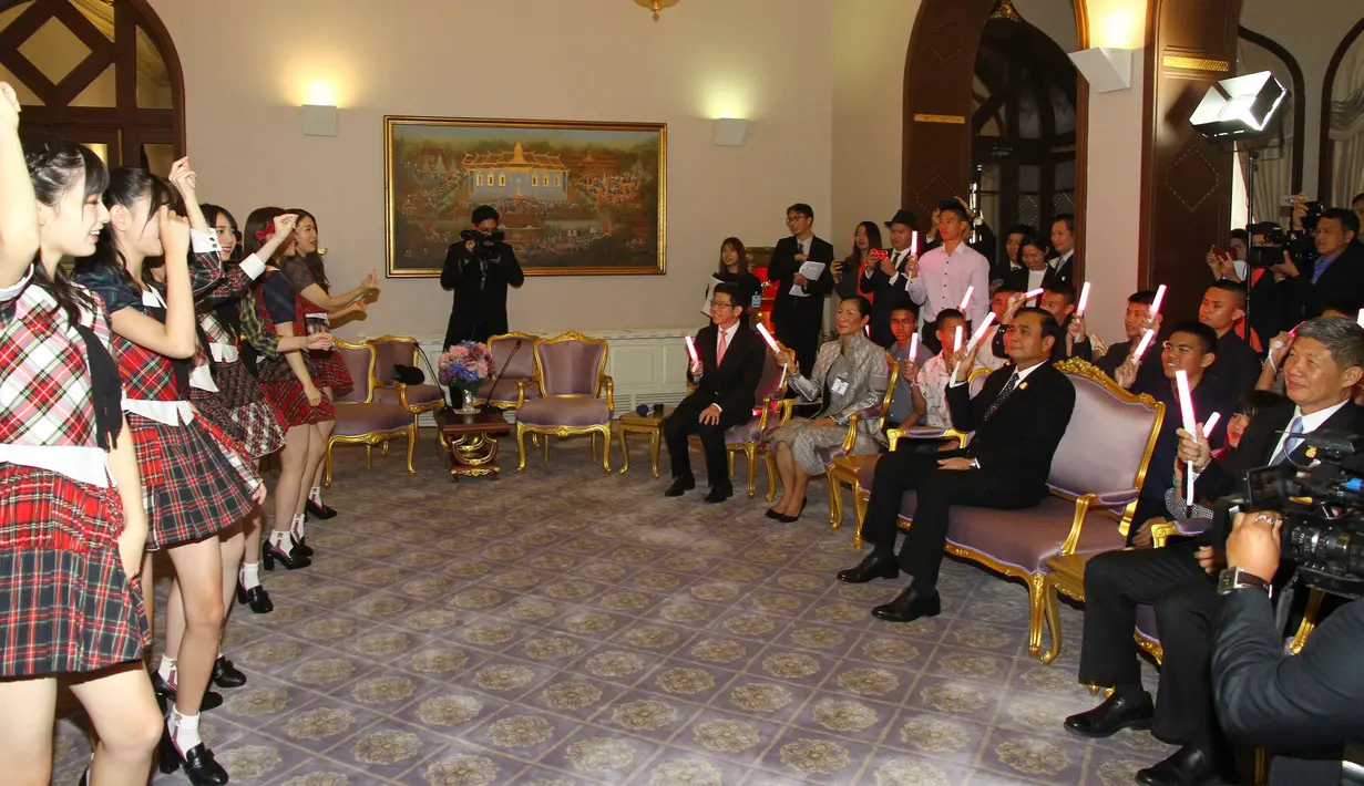 PM Thailand, Prayut Chan-O-Cha menyaksikan penampilan grup musik Jepang, AKB48, di Gedung Pemerintahan, Kamis (13/8). Kunjungan ini adalah promosi AKB48 untuk mempersiapkan konser di Bangkok pada Desember mendatang. (Government Spokesman Office via AP)