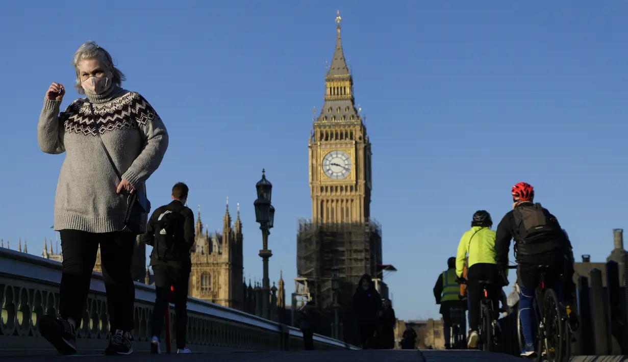 Orang-orang berjalan di atas Jembatan Westminster di London, pada Kamis (20/1/2022). Pemerintah Inggris mengakhiri pembatasan COVID-19, termasuk mandat masker, bekerja dari rumah dan paspor vaksin mulai Kamis. (AP Photo/Kirsty Wigglesworth)