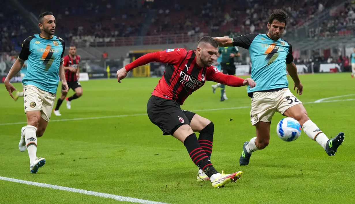 Penyerang AC Milan, Ante Rebic (kiri) berebut bola dengan bek Venezia, Pietro Ceccaroni pada laga pekan ke-5 Serie A 2021/22 di San Siro, Kamis (23/9/2021) dini hari WIB. AC Milan Milan menaklukkan tamunya Venezia 2-0. (AP Photo/Antonio Calanni)