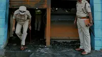Polisi India mengecek restoran yang terbakar di Bangalore (8/1). Lima pekerja restoran tewas akibat kebakaran tersebut. Menurut Polisi, kurang dari dua minggu kebakaran telah terjadi di restoran lain menewaskan 14 orang. (AFP Photo/Manjunath Kiran)