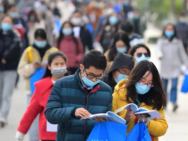 Para peserta mempelajari materi pelajaran sembari menunggu untuk mengikuti ujian pegawai negeri sipil (PNS) nasional China di sebuah sekolah di Kota Wuxi, Jiangsu, China pada 29 November 2020. Ujian PNS nasional China untuk angkatan 2021 diadakan di seluruh penjuru negeri itu. (Xinhua/Xuan Yueliang)