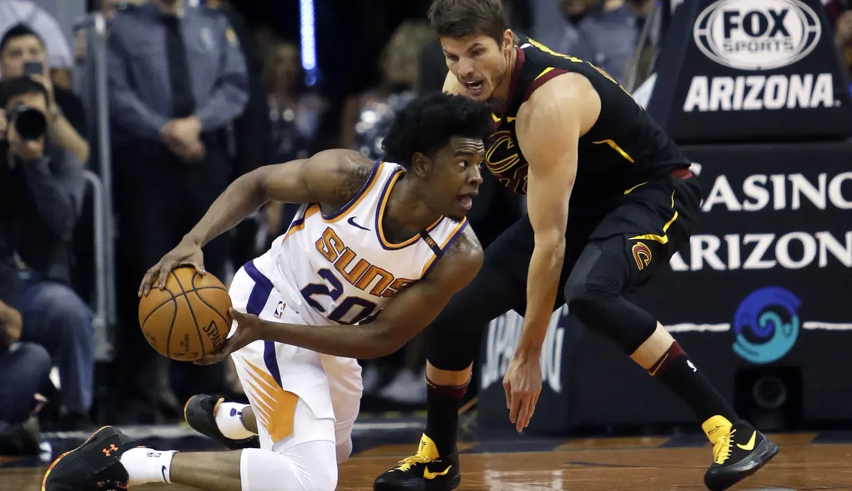Pebasket Phoenix Suns, Josh Jackson, berusaha melewati pebasket Cleveland Cavaliers, Kyle Korver, pada laga NBA di Talking Stick Resort Arena, Rabu (14/3/2018). Cleveland Cavaliers menang 129-107 atas Phoenix Suns. (AP/Rick Scuteri)