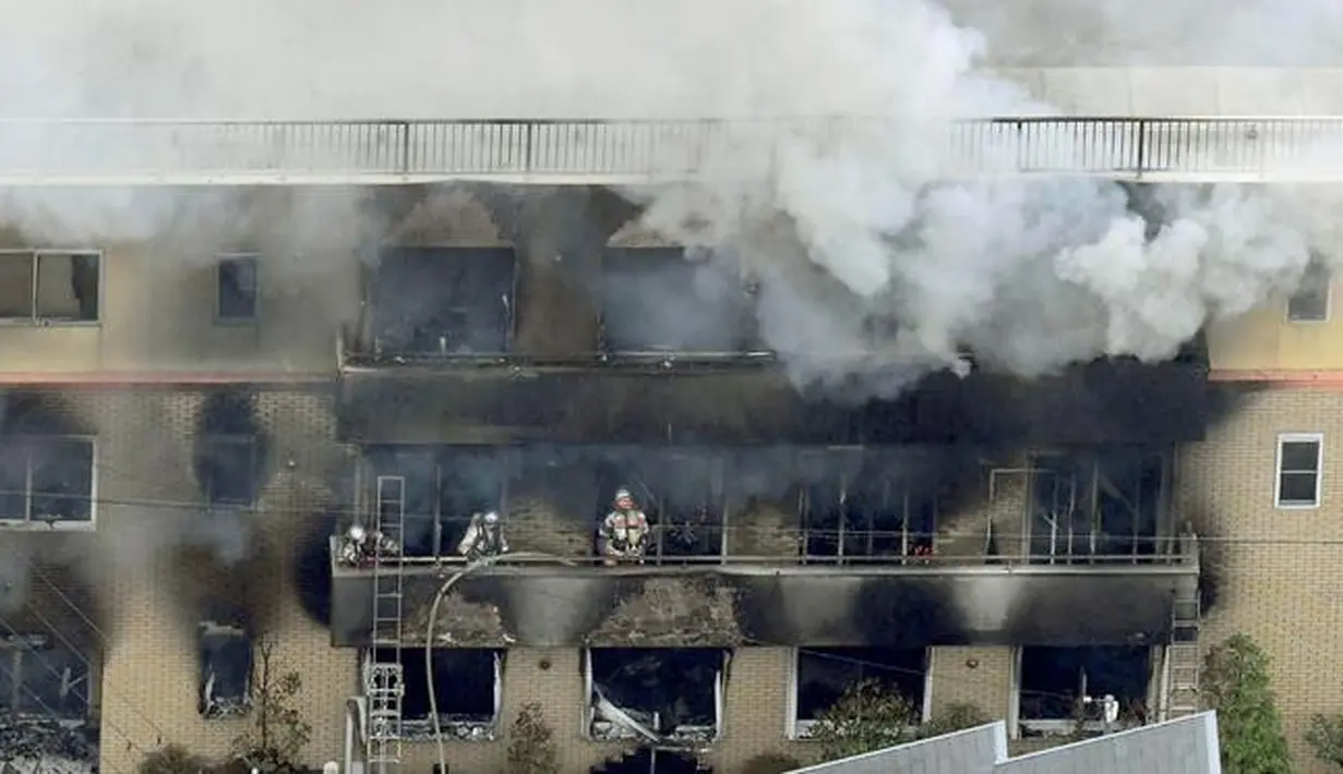 Petugas pemadam kebakaran berjibaku memadamkan api saat kebakaran melanda studio animasi Kyoto Animation di Kyoto, Jepang, Kamis (18/7/2019). Studio tersebut diduga sengaja dibakar oleh seorang. (Kyodo News via AP)