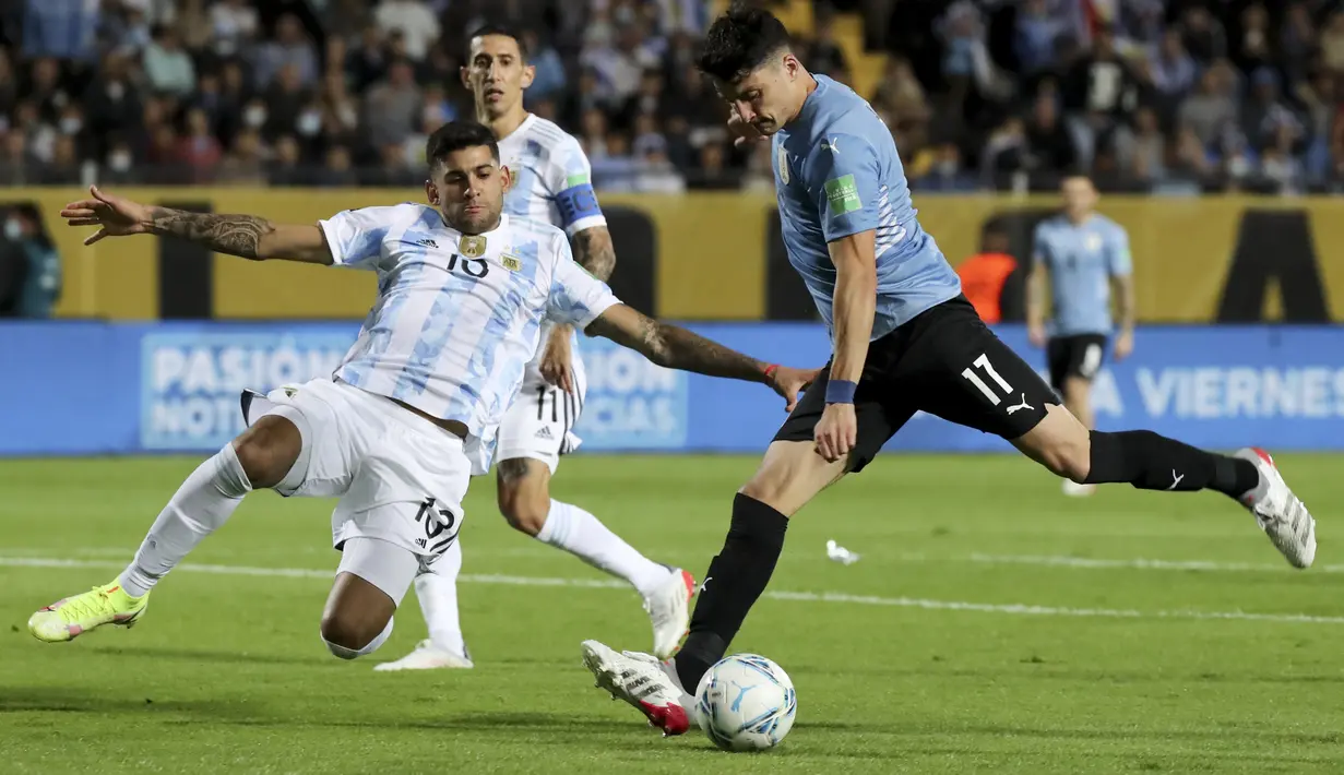 Bek Argentina, Cristian Romero berusaha menghentikan tembakan pemain Uruguay, Joaquin Piquerez pada penyisihan Piala Dunia di Estadio Campeon del Siglo, Montevideo, Uruguay, Sabtu (13/11/2021). Uruguay masih tercecer di posisi keenam dengan 16 poin dari 13 laga. (Raúl Martínez/Pool Via AP)