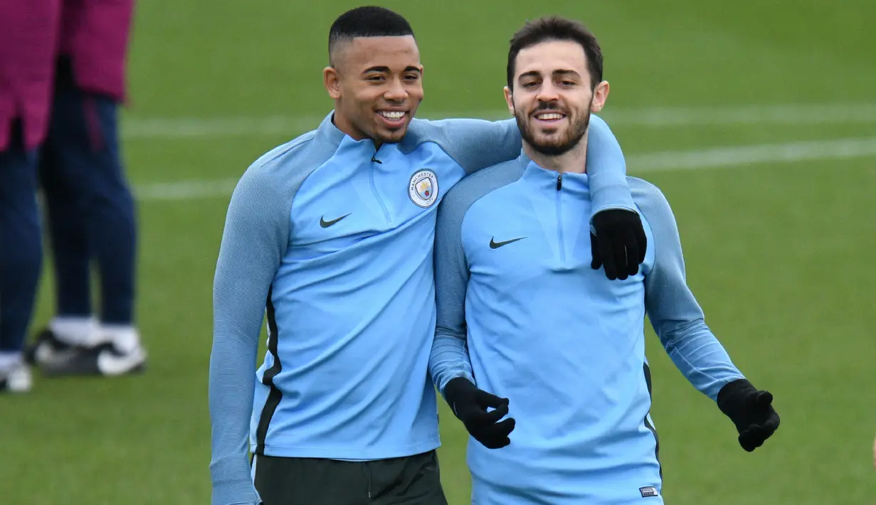 Pemain Manchester City, Gabriel Jesus merangkul Bernardo Silva saat sesi latihan jelang laga Liga Champions di Manchester, Selasa (6/3/2018). Manchester City akan berhadapan dengan FC Basel. (AFP/ Oli Scarff)