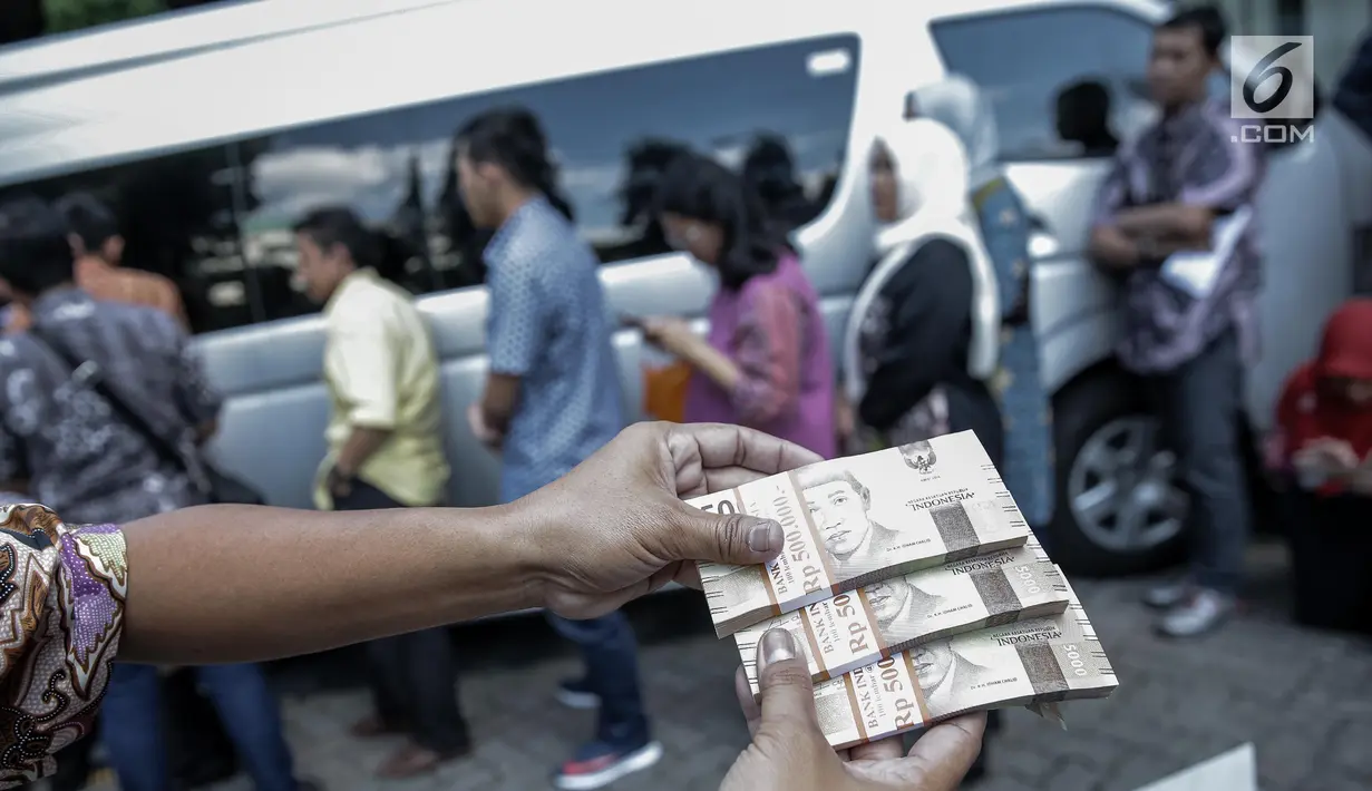 Karyawan memperlihatkan uang pecahan ribuan di kantor KKP, Jakarta, Jumat (16/6). BI siap melayani kebutuhan masyarakat akan uang tunai serta sistem pembayaran yang andal, selama Ramadan dan hari raya Idul Fitri 2017. (Liputan6.com/Faizal Fanani)
