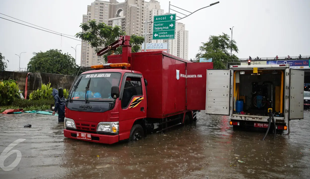 Mobil pompa penyedot air Dinas Tata Air dikerahkan untuk menyedot air banjir yang merendam Jalan Gunung Sahari, Jakarta, Selasa (21/2). Hujan yang mengguyur sejak Selasa dinihari membuat sebagian wilayah di Jakarta banjir. (Liputan6.com/Faizal Fanani)