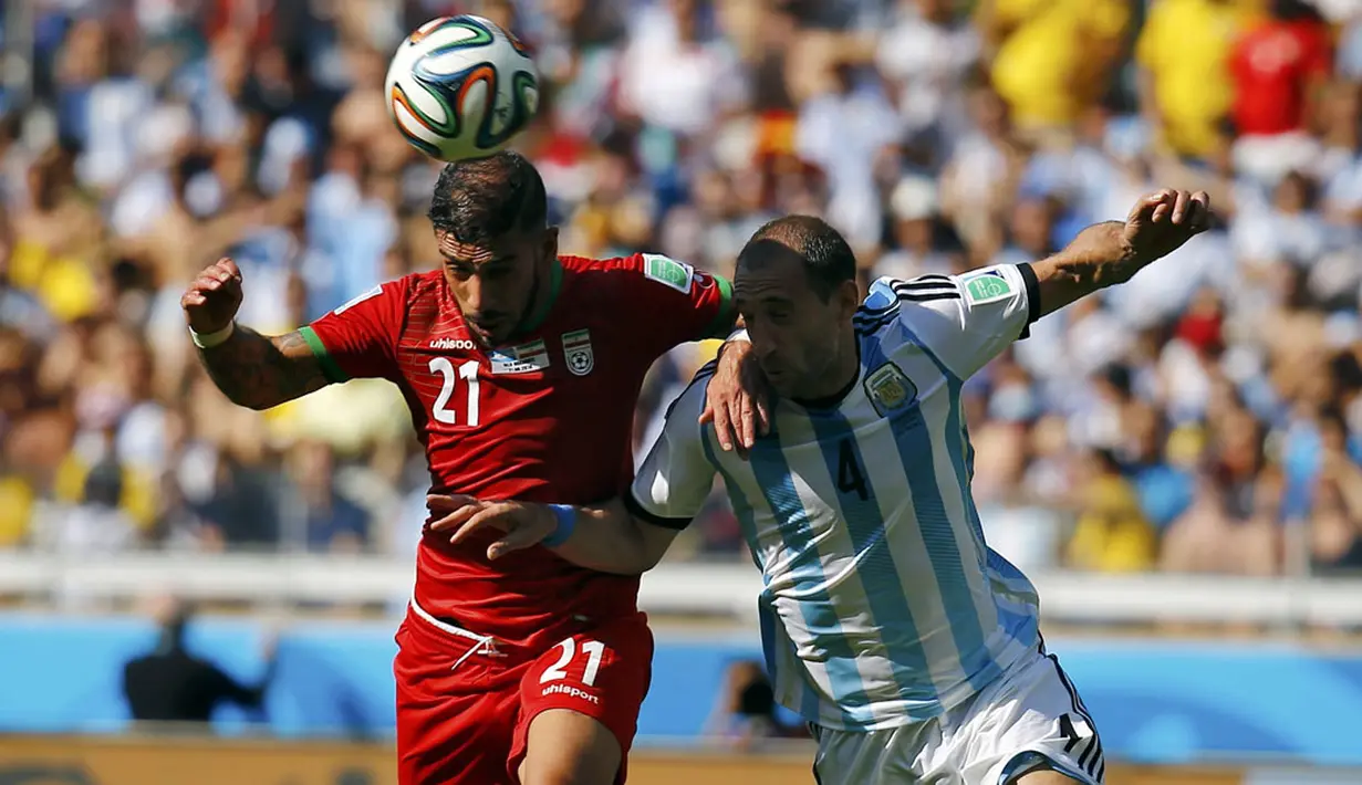 Gelandang Iran, Ashkan Dejagah (kiri), berusaha melewati hadangan Pablo Zabaleta (Argentina) saat berlaga di babak penyisihan Piala Dunia Grup F di Stadion Mineirao, Belo Horizonte, Brasil (21/6/2014). (REUTERS/Kai Pfaffenbach)