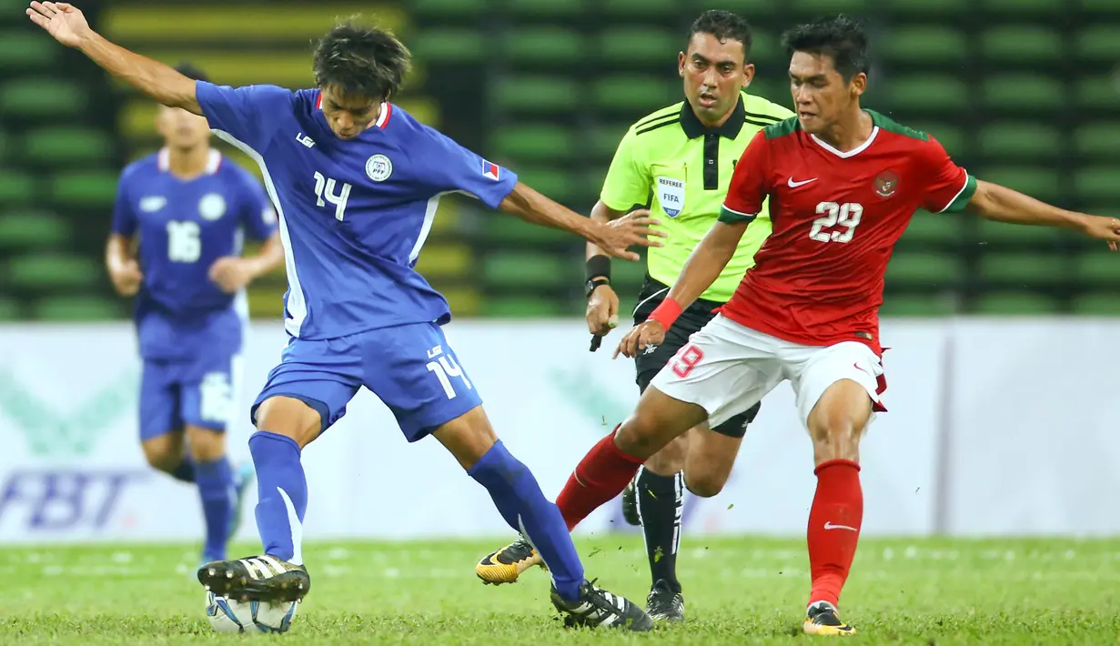 Pemain Filipina Kou Ichi Belgira berusaha mengontrol bola dari kawalan pemain Timnas Indonesia U-22, Septian David Maulana pada laga SEA Games di Stadion Shah Alam, Selangor (17/8). Indonesia menang 3-0 atas Filipina. (AP Photo / Vincent Phoon)
