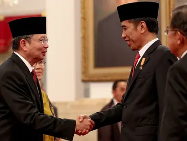 Presiden Jokowi mengucapkan selamat kepada Laksamana Dua (Laksda) Willem Rampangilei (kiri) usai pelantikan dirinya sebagai Kepala Badan Nasional Penanggulangan Bencana (BNPB) di Istana Negara, Jakarta, Senin (7/9/2015). (Liputan6.com/Faizal Fanani)