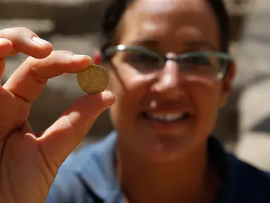 Seorang arkeolog Israel menunjukkan koin emas yang ditemukan di sebuah situs arkeologi di Kota Yavne, Israel tengah, pada 25 Agustus 2020. Harta karun langka berupa 425 koin emas murni berumur sekitar 1.100 tahun ditemukan di Israel tengah. (Xinhua/Gil Cohen Magen)