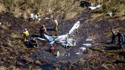Petugas penyelamat memeriksa lokasi jatuhnya pesawat Beechcraft Baron yang jatuh dekat bandara di Ayolas, Paraguay, Kamis (26/7). Pesawat ringan bermesin ganda itu jatuh pada Rabu (25/7) sore waktu setempat. (Carlos Juri/Grupo La Nacion/AFP)