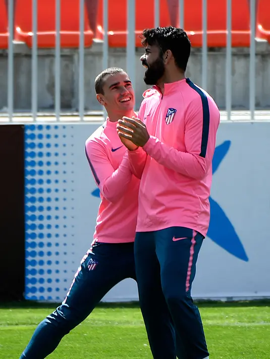 Penyerang Atletico Madrid, Antoine Griezmann dan Diego Costa bercanda saat sesi latihan di Ciudad Deportiva Wanda di Madrid (2/5). Pada leg pertama Atletico Madrid bermain imbang 1-1 atas Arsenal di Emirates Stadium. (AFP Photo/Pierre-Philippe Marcou)