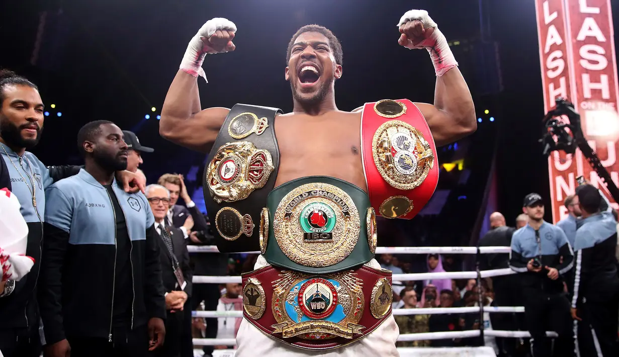 Petinju Anthony Joshua merayakan kemenangannya atas Andy Ruiz Jr dalam kejuaraan tinju kelas berat dunia di Diriyah Arena, Riyadh, Arab Saudi, Minggu (8/12/2019). Anthony Joshua menang angka mutlak atas Andy Ruiz Jr. (Nick Potts/PA via AP)