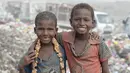 Dua anak laki-laki berpose saat diambil gambarnya di tempat pembuangan sampah, dimana mereka mengumpulkan sampah untuk didaur ulang, di kota Houdieda, Yaman, Rabu (20/1). (REUTERS/Abduljabbar Zeyad)