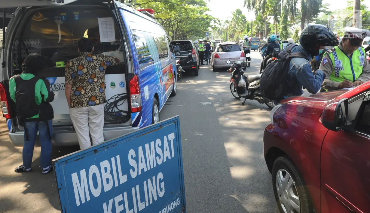 Petugas memeriksa pajak STNK saat melakukan razia gabungan di kawasan Naggewer, Bogor, Selasa (18/9). Razia yang melibatkan unsur POLRI, POM, Dishub dan Dispenda ini menyasar pemilik kendaraan yang belum membayar pajak kendaraan. (Merdeka.com/Arie Basuki)