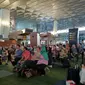 penumpang pesawat di terminal 3 Bandara Soekarno Hatta memainkan angklung dengan dipandu seorang instruktur (Liputan6.com/Pramita Tristiawati)