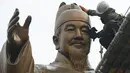 Pekerja membersihkan patung perunggu Raja Sejong di plaza Gwanghwamun di Seoul (9/4). Raja Sejong adalah penguasa Korea kedua yang mendapatkan gelar Raja Yang Agung atau Raja Besar setelah Raja Gwanggaeto dari Kerajaan Goguryeo. (AFP Photo/Jung Yeon-Je)