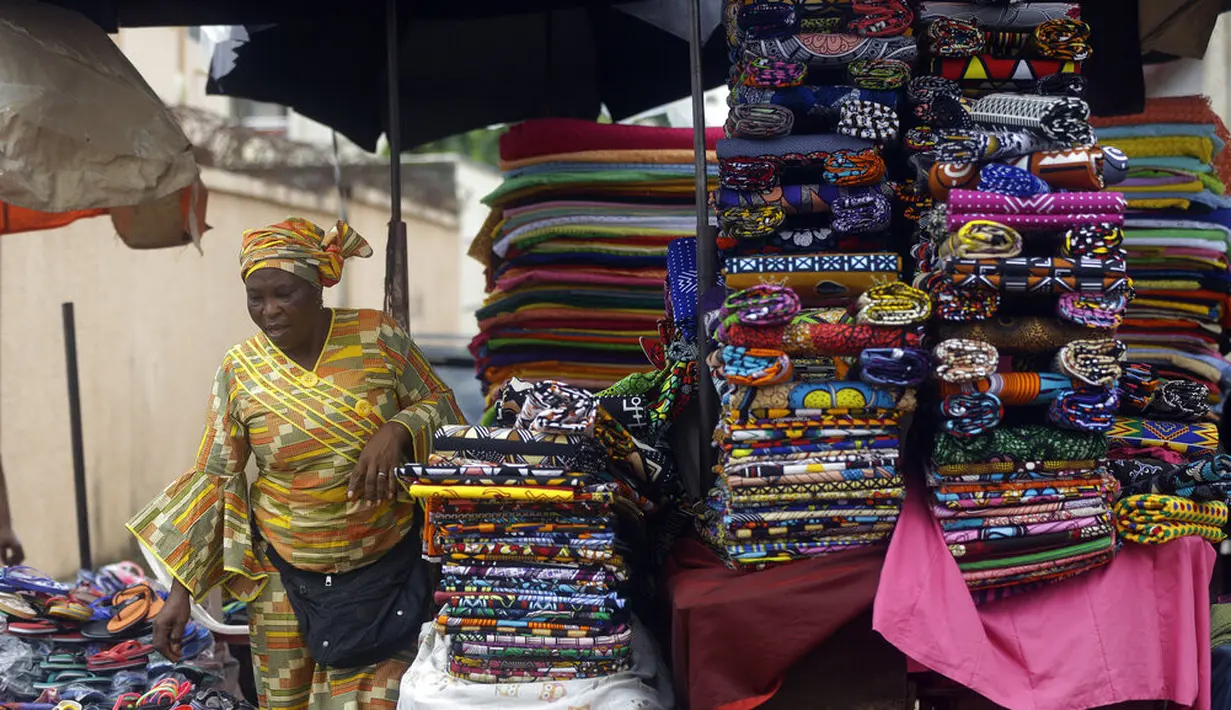 Seorang perempuan menjual kain di pasar Kaporo di Conakry, Guinea, Senin (13/9/2021). Pasukan elit militer Guinea melakukan kudeta dan menangkap Presiden Alpha Conde pada Minggu, 5 September lalu. (AP Photo/ Sunday Alamba)