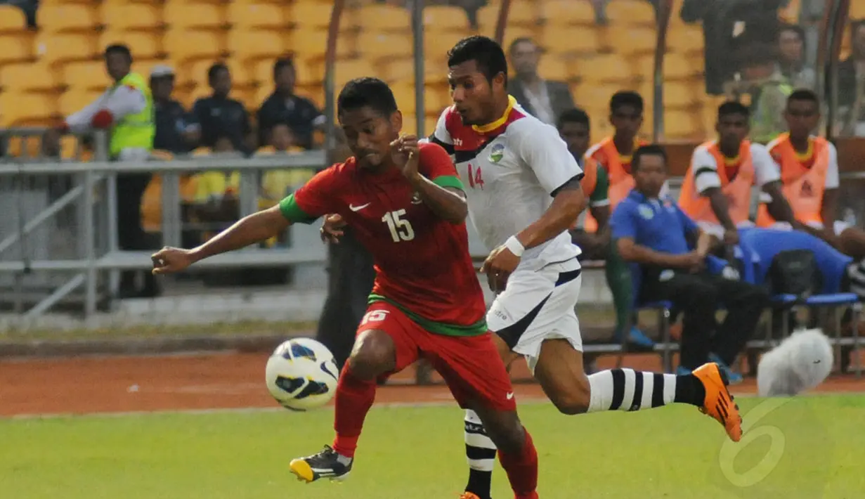 Gelandang Timnas Indonesia, Ramdani Lestaluhu (depan) berusaha melewati Chiquito FilipeDo Carmo (Timor Leste) saat berlaga di Stadion GBK Jakarta, Selasa (11/11/2014). Indonesia unggul 4-0 atas Timor Leste. (Liputan6.com/Helmi Fithriansyah)