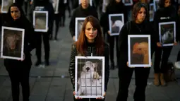 Sejumlah aktivis dari Igualdad Animal mebawa poster bergambar hewan saat melakukan aksi protes di di Madrid, Spanyol (10/12). Mereka bergerak dalam organisasi non-profit yang tujuannya ingin menyetarakan hak binatang. (Reuters/Javier Barbancho)