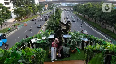 Warga berswafoto di Jembatan Penyeberangan Orang (JPO) Phinisi di jalan Jenderal Sudirman, Jakarta, Jumat (10/5/2024). (Liputan6.com/Herman Zakharia)