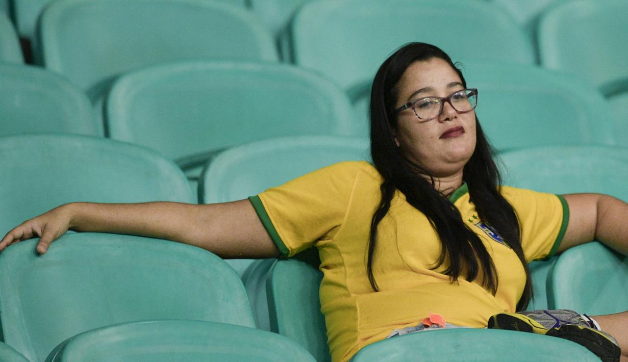 Ekspresi suporter Brasil yang tampak tidak bersemangat saat memyaksikan laga Brazil vs Venezuela di Arena Fonte Nova, Salvador, Brasil. (AP/Natacha Pisarenko)