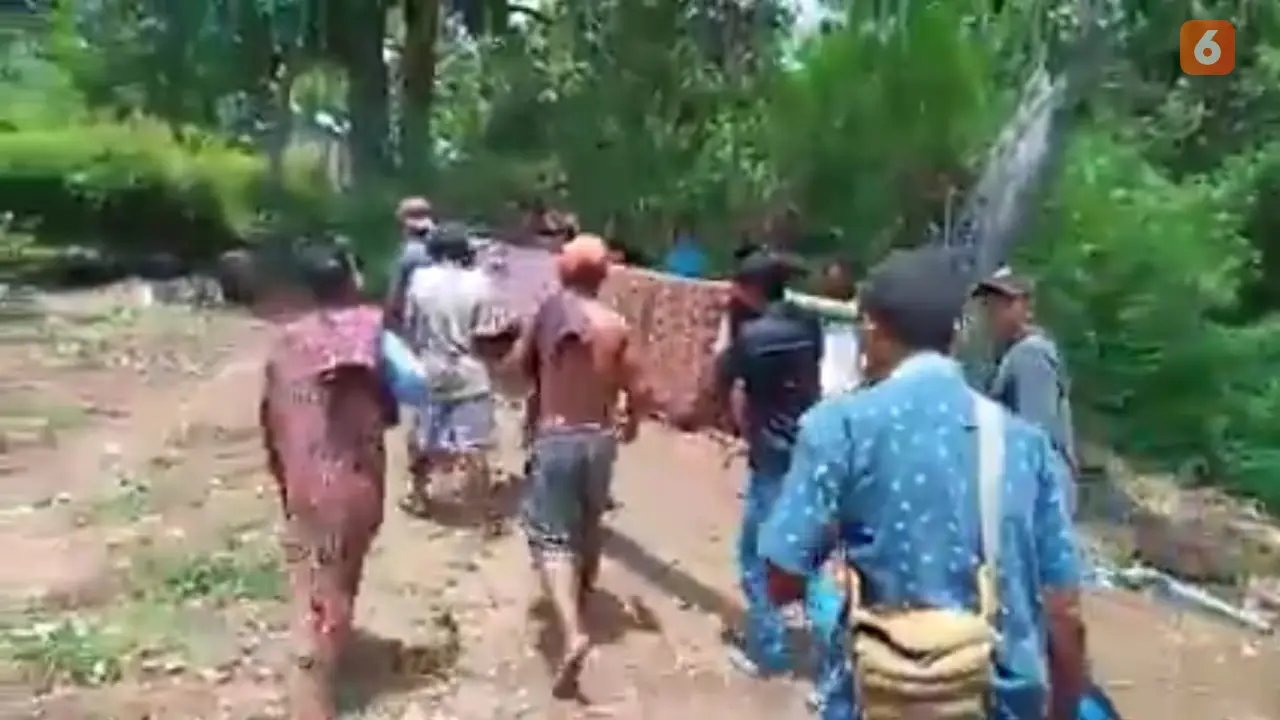 Warga Dusun Glak, Desa Hale, Kecamatan Mapitara, Kabupaten Sikka, NTT sedang menandu pasien melewati jalan rusak menuju puskesmas Mapitara (Liputan6.com/ Dionisius Wilibardus)