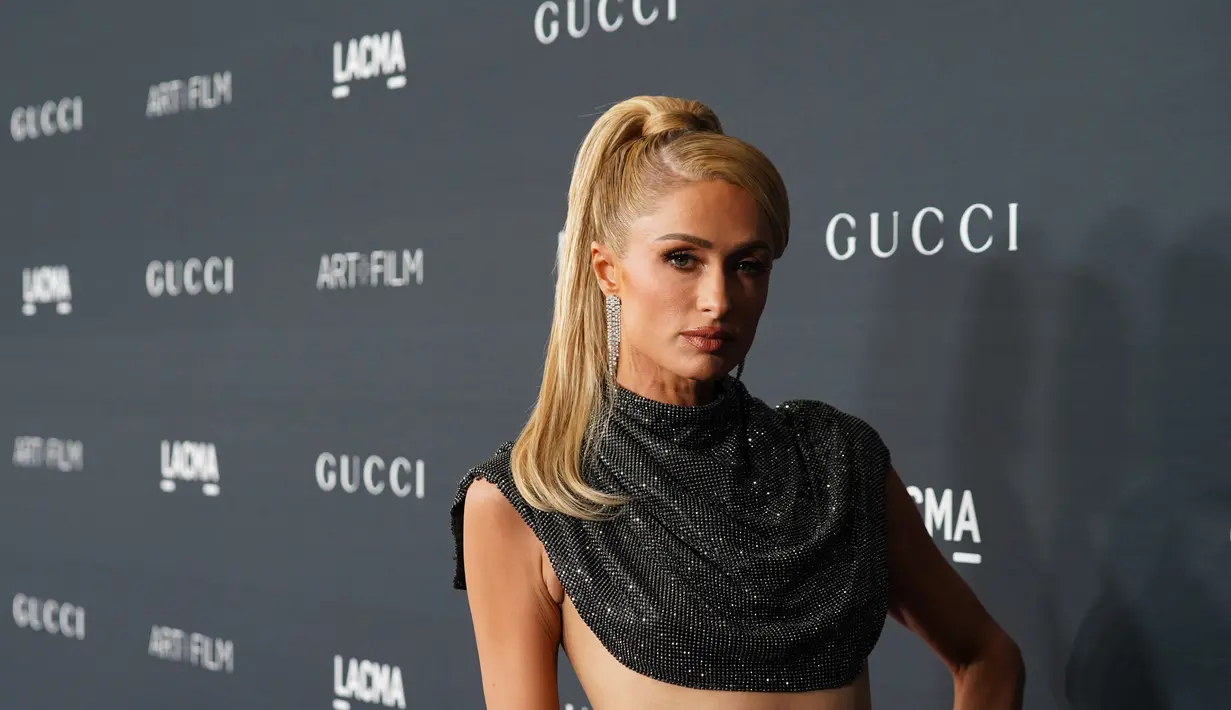 Paris Hilton berpose saat menghadiri LACMA ART+FILM GALA 2022 yang dipersembahkan Oleh Gucci di Los Angeles County Museum of Art di Los Angeles, California pada 5 November 2022. Bintang reality show berusia 41 tahun itu melangkah ke karpet merah mengenakan gaun berkilauan dengan korset cantik yang mengarah ke bagian tengah tubuh terbuka yang diikat. Muncul dari ikat pinggang tipis muncul rok asimetris dengan celah sisi panjat yang berisiko yang memungkinkan sepatu Hilton bersinar. (Presley Ann/Getty Images for LACMA/AFP)