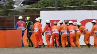 Para marshals membantu Valentino Rossi yang terjatuh pada lap ke-20 di MotoGP Jepang yang berlangsung di Sirkuit Twin Ring Motegi, Minggu (20/10/2019). (AFP/Toshifumi Kitamura)