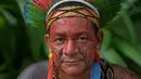Seorang pria bernama Garapira dari suku Pataxo berpose untuk difoto di Rio de Janeiro, Brasil (14/4). Brasil merayakan Indian Day yang digelar setiap tanggal 19 April untuk menghormati masyarakat adat dan budaya setempat. (AFP/Carl De Souza)