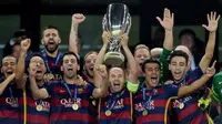 Kapten Barcelona, Andres Iniesta bersama rekan-rekannya mengangkat piala usai menaklukan Sevilla pada laga UEFA Super Cup di Tbilisi, Georgia, Selasa (11/8/2015). Bercelona menang 5-4 atas Sevilla. (AFP Photo/Kirill Kudryavtsev)