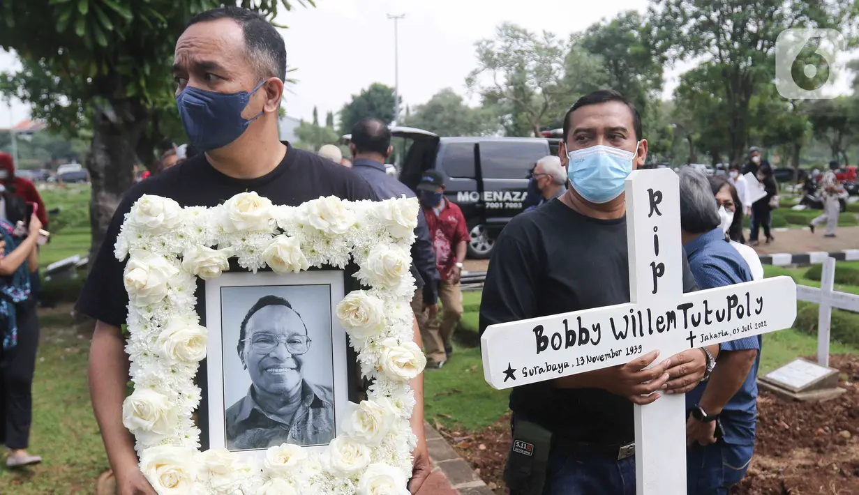 Keluarga membawa foto musisi legendaris Bob Tutupoly semasa hidup menjelang pemakaman di Tempat Pemakaman Umum (TPU) Tanah Kusir, Jakarta, Kamis (7/7/2022). Almarhum Bob Tutupoly meninggal setelah mengalami stroke dan penyakit penyerta. (Liputan6.com/Herman Zakharia)