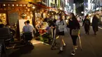 Sejumlah wanita berjalan sementara yang lain makan dan minum di restoran dan bar pada malam pertama pencabutan status darurat virus corona oleh pemerintah di Tokyo, Jepang, Jumat (1/10/2021). (AP Photo/Hiro Komae)