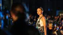 Gigi Hadid berpose saat mengenakan busana VOGUE World: New York selama New York Fashion Week 2022 di New York City (12/9/2022). Gigi juga mengenakan balutan jeans baggy denim dan singlet putih. (Sean Zanni/Getty Images for Vogue/AFP)