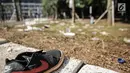 Sepatu terlihat di antara sisa sampah bekas pertandingan Final Piala Presiden 2018 di area Stadion Utama Gelora Bung Karno, Jakarta, Senin (19/10). Sampah-sampah itu ditinggalkan para suporter Persija Jakarta dan Bali United. (Liputan6.com/Faizal Fanani)