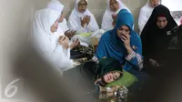 Julia Perez atau Jupe membaringkan tubuhnya di pangkuan ibunya, Sri Wulansih, disela acara pengajian di Kelapa Dua, Depok, Kamis (29/12). Bercucuran air mata,  Jupe minta didoakan sembuh dari kanker serviks yang diderita. (Liputan6.com/Herman Zakharia)