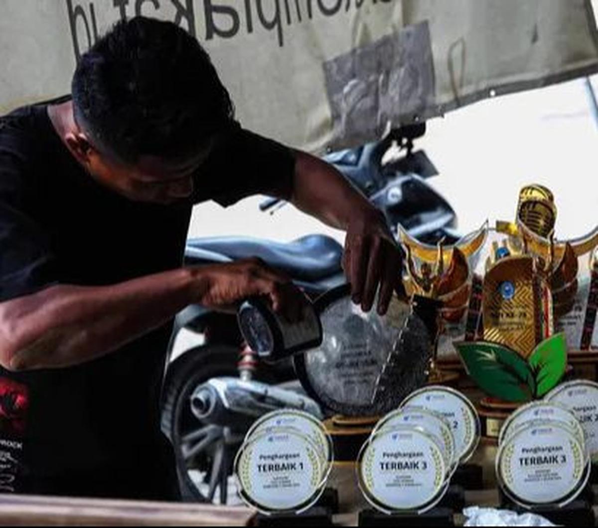 Pekerja menyelesaikan pembuatan plakat dan piala untuk pemenang lomba di kawasan Ciledug, Kota Tangerang, Banten, Rabu (7/8/2024).&nbsp;Jelang perayaan HUT ke-79 Kemerdekaan RI, permintaan plakat dan piala meningkat hingga 20 persen.&nbsp;Foto: Liputan6.c