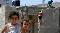 Anak-anak bermain saat Hari Nakba di sebelah rumah mereka di kamp pengungsian Al-Shati, Jalur Gaza, Palestina, Rabu (15/5/2019). Hari Nakba di mana ratusan ribu rakyat Palestina eksodus dari tanah kelahirannya telah mengubah kehidupan mereka selama tujuh dekade terakhir. (MOHAMMED ABED/AFP)