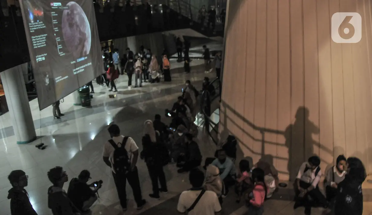 Warga menyaksikan fenomena gerhana bulan total atau Bloodmoon di Taman Ismail Marzuki, Jakarta Pusat, Selasa (8/11/2022). Gerhana Bulan total 8 November ini akan menjadi yang terakhir selama tiga tahun, karena gerhana Bulan total berikutnya terjadi pada 14 Maret 2025. (merdeka.com/Iqbal S Nugroho)