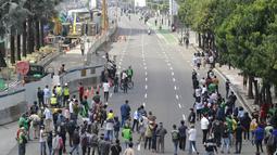 Warga tumpah ruah hingga ke jalan saat melihat parade pembalap MotoGP di depan Sarinah Thamrin, Jakarta Pusat. Sebanyak  20 pembalap melakukan parade motor dari Istana Merdeka menuju Hotel Kempinski di Bundaran HI Jakarta Pusat, Rabu (16/03/2022). (Bola.com/M Iqbal Ichsan)