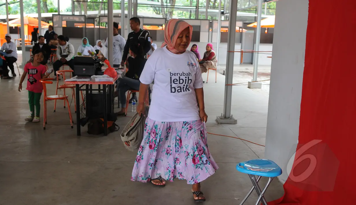 Seorang pedagang saat bersiap melakukan sesi foto untuk pembuatan tanda pengenal di Kawasan Lenggang Jakarta, Monumen Nasional, Jakarta, Rabu (8/4/2015). (Liputan6.com/Herman Zakharia)