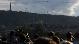 Penonton menyaksikan aksi akrobat perempuan, Tatiana Mosio Bongonga, berjalan meniti tali melintas di atas sungai Vltava di ibu kota Ceko, Praha, Rabu (14/8/2019). Tatiana  berjalan di ketinggian 35 meter tanpa menggunakan alat pengaman sama sekali. (Michal Cizek / AFP)