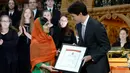 Aktivis HAM, Malala Yousafzai menerima sertifikat warga negara kehormatan dari PM Kanada, Justin Trudeau di Ottawa, Rabu (12/4). Malala menjadi orang termuda dan orang keenam penerima anugerah itu dari Kanada. (Justin Tang/The Canadian Press via AP)