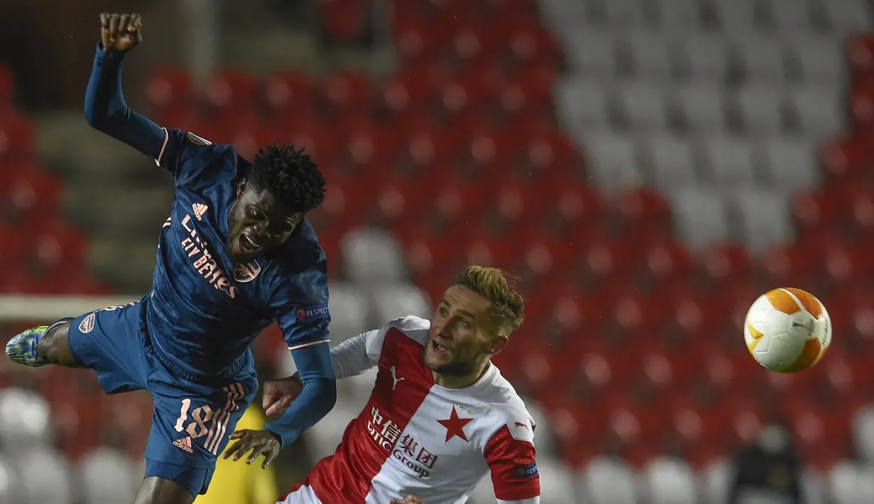 Striker Slavia Praha, Jan Kuchta (kanan) berebut bola dengan gelandang Arsenal, Thomas Partey dalam laga leg kedua perempatfinal Liga Europa 2020/2021 di Sinobo Stadium, Praha, Kamis (15/4/2021). Slavia Praha kalah 0-4 dari Arsenal. (AFP/Michal Cizek)