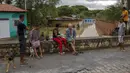 Orang-orang tetap di tempat yang kering saat banjir akibat hujan lebat di Itapetinga, Negara Bagian Bahia, Brasil, 26 Desember 2021. Banjir membuat 35.000 orang terpaksa mengungsi. (Manuella LUANA/AFP)