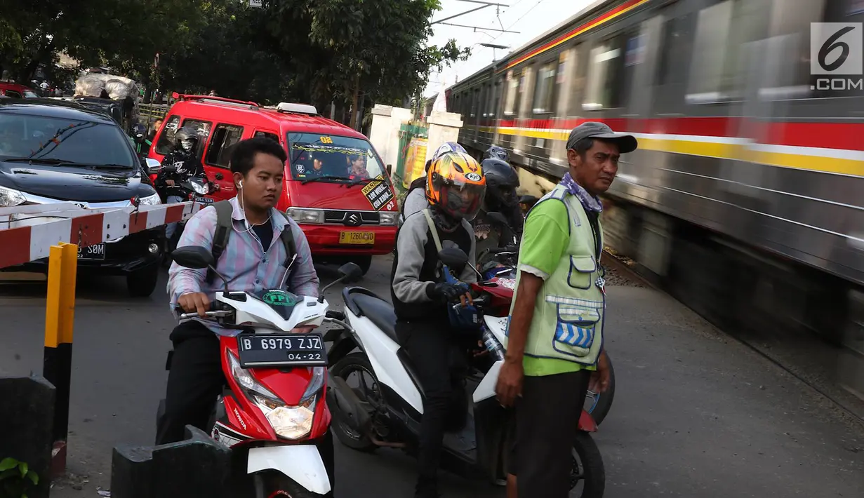 Kereta api melintas di kawasan Lenteng Agung, Jakarta, Kamis (14/3). Pembangunan jalan layang (fly over) berbentuk tapal kuda di perlintasan kereta tersebut diprediksi akan mengurangi tingkat kemacetan antara 40-50 persen. (Liputan6.com/Immanuel Antonius)