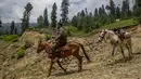 Seorang warga Kashmir bersama kudanya menaiki jalan perbukitan di Tosamaidan, barat daya Srinagar, Kashmir yang dikuasai India (21/6/2021). Tidak hanya terkenal dengan padang rumputnya, Tosamaidan juga menjadi tujuan wisata. (AP Photo/Dar Yasin)